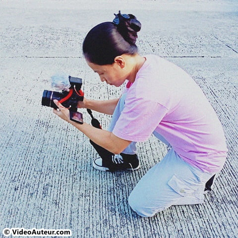 Stepping on the camera strap as DIY camera stabilizer.