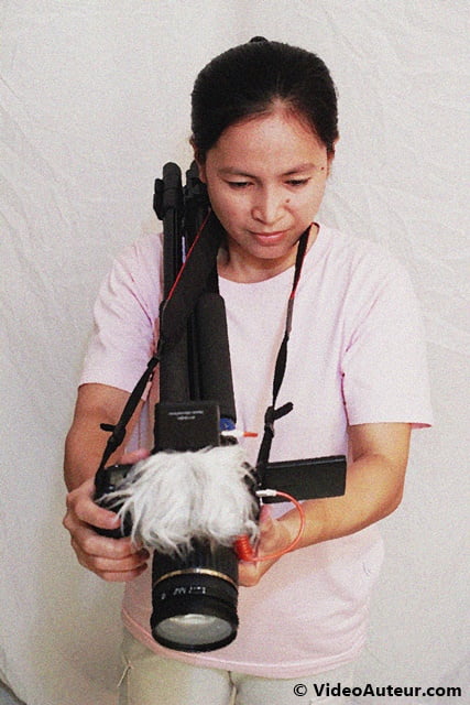 Tripod legs on one shoulder as a form of DIY camera stabilizer.